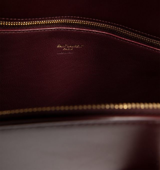 Image 3 of 3 - RED - SAINT LAURENT Sac De Jour Duffle featuring half-moon shape, full zip closure, elongated straps, providing both hand and shoulder carry options, leather lining, bronze-tone hardware, one zip pocket and five metal feet. 16.5" x 10.8" x 0.84.7". Calfskin leather. Made in Italy. 