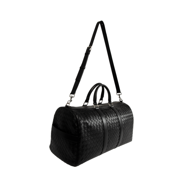 Image 2 of 3 - BLACK - Bottega Veneta Duffle bag in Intrecciato leather with adjustable and detachable strap. Featuring single exterior side zipped pocket, one interior zipped pocket, double flat open pockets, and zip closure.  Material: calfskin. Lining: Canvas. Hardware: Silver finish. Measures 11.4 high x 21.7 wide x 9.4" deep with 5.9" handle drop and 20.9 strap drop. Made in: Italy. 