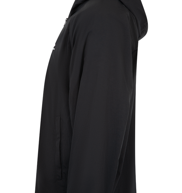 Image 3 of 3 - BLACK - BALENCIAGA Technical Tracksuit Jacket featuring technical polyamide, hooded design, high neck, double-ended zip fastening, long raglan sleeves, contrasting piping, 2 zipped slash pockets, 2 inner vertical zipped pockets, loop sports icon artwork embroidered on chest, adjustable drawstring at hem and elasticated cuffs. 100% polyamide. Lining: 100% polyester. Made in Italy. 