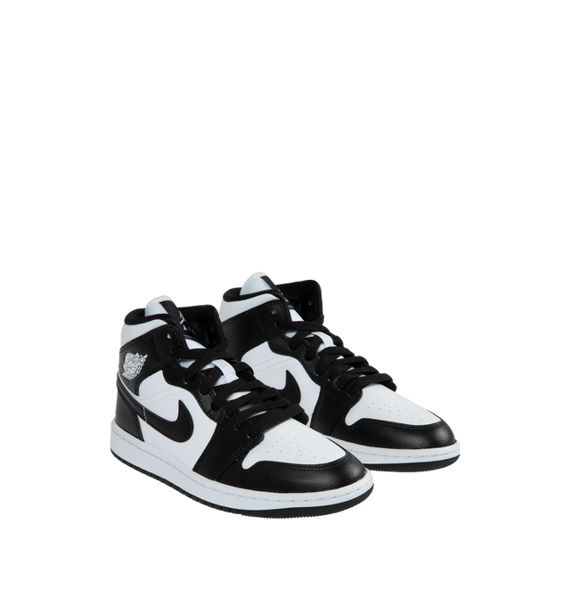 Image 2 of 5 - BLACK - JORDAN Air Jordan 1 Mid featuring genuine and synthetic leathers, padded tongue and inner upper, iconic winged Air Jordan logo on upper, encapsulated Air unit, Solid rubber outsole, stitched-down Swoosh logo and wings logo on the collar. 