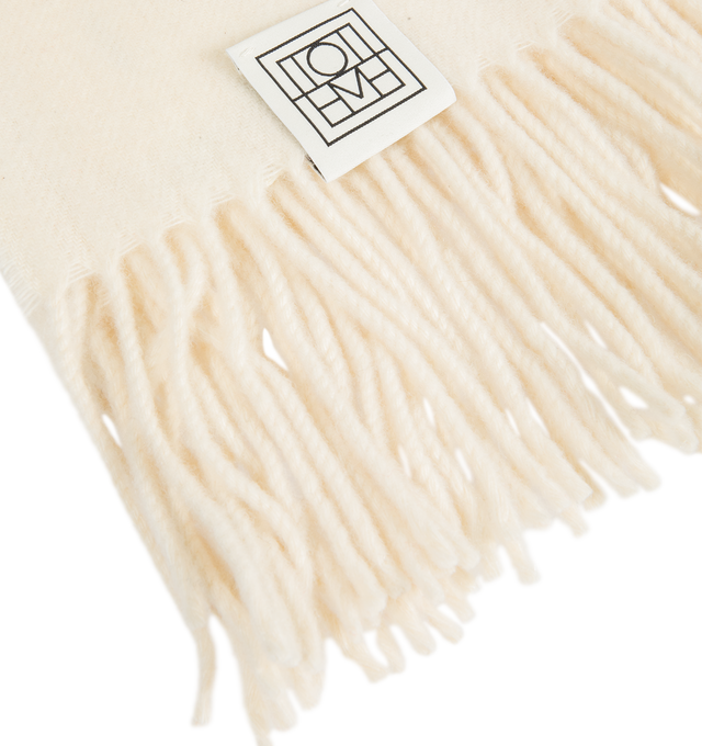 Image 2 of 2 - CREAM - Toteme Women's Fringed Cashmere Blend Scarf is crafted from a luxurious cashmere blend and features a timeless oversized silhouette designed for versatile cold-weather layering. Main Material: 90% Recycled GRS Cashmere, 5% Cashmere, 3% Wool.  
