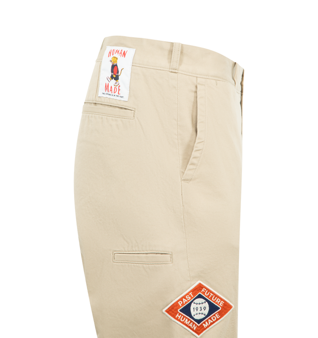 Image 4 of 4 - NEUTRAL - HUMAN MADE College Pants featuring high-density cotton chino cloth, relaxed silhouette, zip fly, brand message printed inside the back waist, bear label above one back pocket, heart button on the other, two side and back pockets and double roll-up cuff. 100% cotton. Made in Japan. 