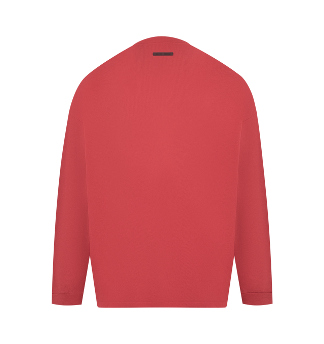 Image 2 of 3 - RED - Fear of God Essentials 90's Long Sleeve Tee is made from 100% cotton jersey, offering a soft yet substantial hand feel. Designed in an oversized 90s-inspired silhouette, it features exaggerated proportions with dropped shoulders for a relaxed drape that tapers to rib-knit cuffs. The front is defined by a HD print application of the Fear of God Essentials lockup alongside the Essentials logos on the sleeves. The signature rubberized Fear of God Essentials label at the collar.Fit Note: Si 