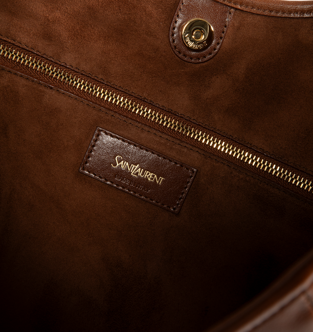 Image 3 of 3 - BROWN - Saint Laurent Women's Mombasa Medium Hobo Bag is crafted from supple calfskin leather in burnt bread brown with a tonal suede lining. Bronze-tone hardware, a leather-covered handle for hand or shoulder carry, a magnetic closure, and an interior zip pocket complete the design. Fits a large phone, slim wallet, keys, and sunglasses. Main Material: 100% Calfskin Leather. Lining: 100% Suede. Dimensions: 2440 x 2433 x 3 cm / 9.415.7 x 9.413 x 1.2 in. Handle Drop: 23 cm / 9.1 in. Made in Ita 