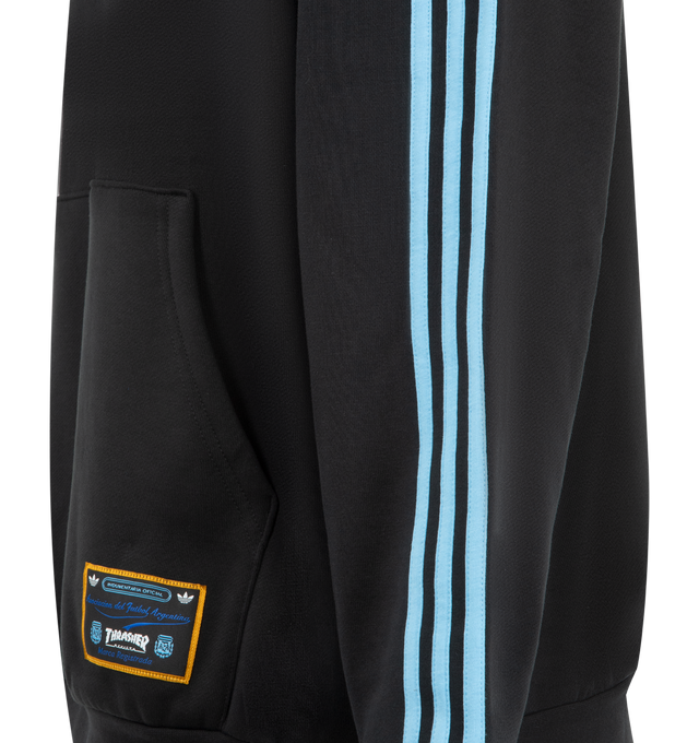 Image 3 of 3 - BLACK - ADIDAS x Thrasher x Argentina Hoodie featuring knit fleece fabric, relaxed loose fit, drawstring hood, kangaroo pocket, stripes down sleeve and logos throughout. 82% cotton, 18% polyester. Made in Vietnam. 