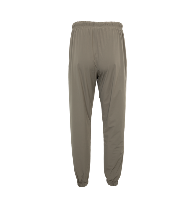 Image 2 of 4 - BROWN - Fear of God Essentials track pant made in stretch woven nylon and designed in a classic straight leg fit. Featuring rubberized label is at the center front, encased elastic waistband with elongated drawstrings with rubberized tips, side seam pockets, and ankle zippers. 86% Nylon, 14% spandex. 
