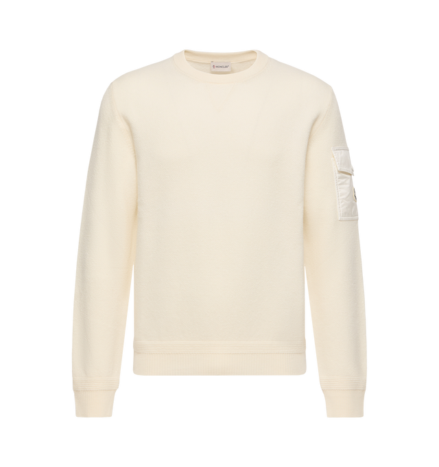 Image 1 of 1 - NEUTRAL - Moncler Mens Wool Sweater is crafted from extra fine virgin wool and features a classic crew neck, signature Longue Saison nylon sleeve pocket with snap button closure, and an embroidered logo patch. This designer wool sweater combines premium knit construction with iconic Moncler detailing for elevated everyday layering. Main Material: 100% Virgin Wool; Trim: 100% Polyamide; Padding: 100% Polyester. Made in Bulgaria. 