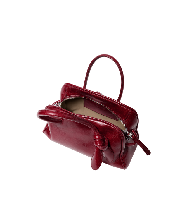 Image 3 of 3 - RED - JACQUEMUS Le Petit Turismo Bag featuring bowling bag in shiny vintage-finished leather, double-sided zipper, tubular handles in matching leather, knotted detail on handle, removable cross-body strap, embossed logo and interior pocket. 10.2 in x 6.3 in x 4.3 in. 100% cow leather. Lining: 100% cotton. Made in Italy. 