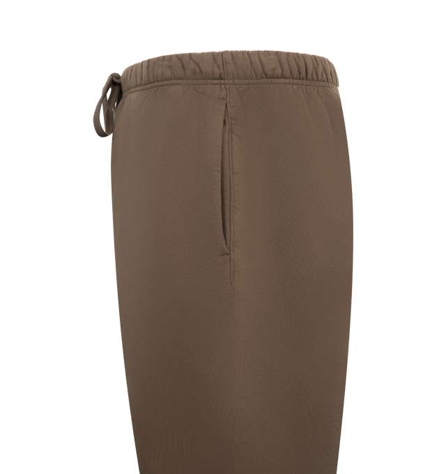 Image 3 of 3 - BROWN - FEAR OF GOD ESSENTIALS Heavy Fleece Flare Sweatpant featuring 520gsm heavy fleece treated with a pigment dye, relaxed, flared-leg silhouette, HD-printed graphicsFear of God on one leg and Essentials on the other, encased elastic waistband with elongated drawcords, side seam pockets and a Fear of God Essentials rubberized label stitched at the center front. 100% cotton. 