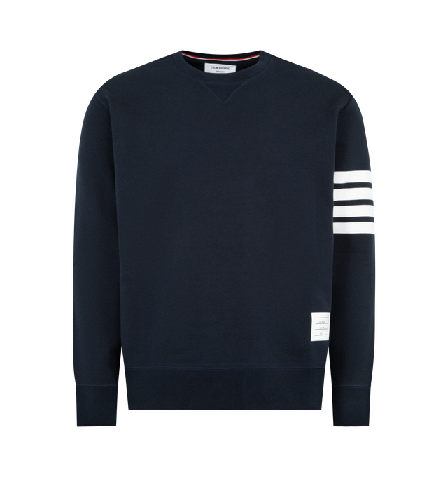 Image 1 of 3 - NAVY - THOM BROWNE Classic Loopback 4 Bar Sweatshirt featuring crew neckline with VPatch, engineered 4-bar stripe detail at left sleeve, name tag applique above hem, buttoned side vents with signature striped grosgrain trim and signature striped grosgrain loop tab at back of neck. 100% cotton. Made in Japan. 