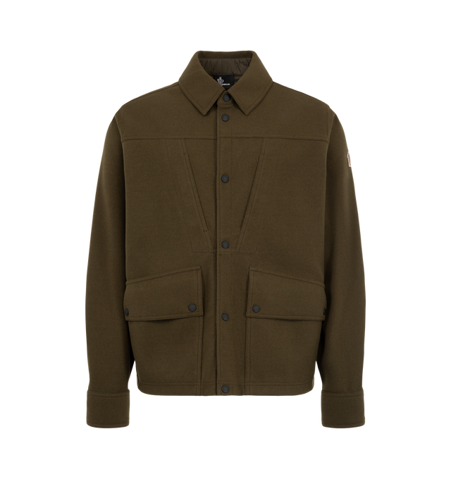 Image 1 of 1 - GREEN - Moncler Grenoble Men's Interlock Overshirt is crafted from a polyester blend interlock knit and features a regular-fit silhouette, a point collar, and a snap-button front closure. Designed as a refined interpretation of mountain utility, this versatile style is structured enough to be worn as a lightweight overshirt and is finished with rainwear lining, adjustable cuffs, and multiple utility pockets with snap-button and hook-and-loop closures. Main Material: 80% Polyester, 10% Acrylic 