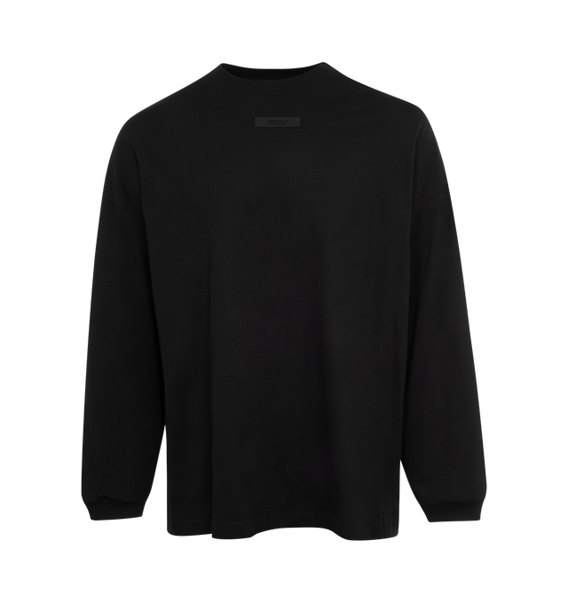 Image 1 of 2 - BLACK - FEAR OF GOD ESSENTIALS Crewneck Long Sleeve T-Shirt featuring rib knit crewneck and cuffs, rubberized logo patch at chest and back and dropped shoulders. 100% cotton. Made in Viet Nam. 