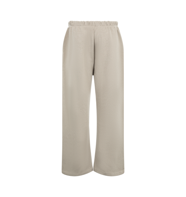 Image 2 of 3 - NEUTRAL - Fear of God ESSENTIALS Men's Signature Flare Sweatpant is crafted from heavyweight 380 GSM cotton-blend fleece and features a relaxed-fit silhouette that extends into a flared leg. Designed with the Essentials signature logo embroidered at the leg, this elevated loungewear style is finished with an encased elastic waistband, elongated drawcords, side-seam pockets, and a signature Essentials label at the center front. Main Material: 80% Cotton, 20% Polyester, 380 GSM.  