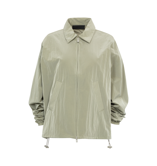 Image 1 of 2 - GREEN - FEAR OF GOD ESSENTIALS Shell Bomber featuring a cropped and rounded silhouette, a classic shirt collar, a rubber brand label at the upper back, a full zipper front closure, and a toggle bungee elastic hem for a customizable fit. 86% woven nylon, 14% spandex. 