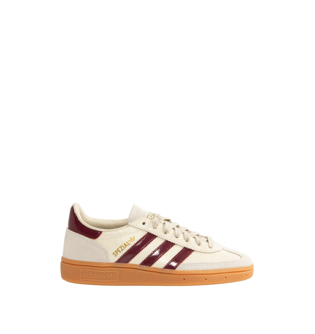 Image 1 of 5 - NEUTRAL - Adidas Men's Handball Spezial Sneakers feature a textured mix of cracked leather, suede overlays, and patent leather 3-Stripes. Designed in a regular fit with a secure lace-up closure, these designer sneakers feature signature Spezial detailing at the quarter and tongue and a soft gum rubber outsole. Upper: Leather. Lining and Insole: Textile and Other Materials. Outsole: Other Materials.  