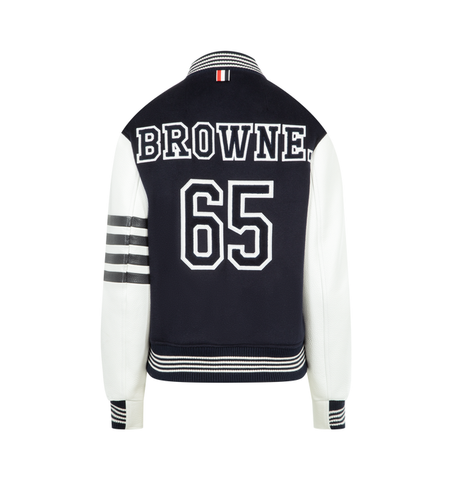 Image 2 of 3 - NAVY - THOM BROWNE Browne 65 Varsity Jacket featuring cashmere with leather sleeves, bold BROWNE. lettering and the number 65 on back appliqud in layered silk and cashmere with satin-stitched edges, 4-bar at the sleeve, front button closure, ribbed bomber collar, cuffs, and hem with 4-bar tipping, welt hand pockets with leather trim, three interior pockets, quilted interior, layered appliqu, relaxed fit and signature striped grosgrain loop tab. 100% wool. Lining: 100% silk. Made in Italy. 
