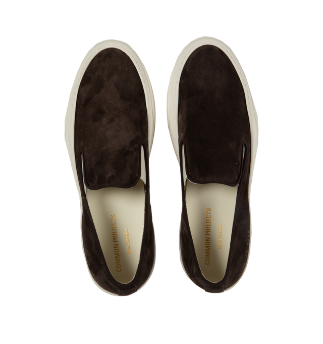 Image 5 of 5 - BROWN - Common Projects minimalist slip-on sneaker crafted from calf suede in a sleek, round-toe profile with thick rubber soles detailed at the heels with signature gold serial number stamp. Made in Italy. 