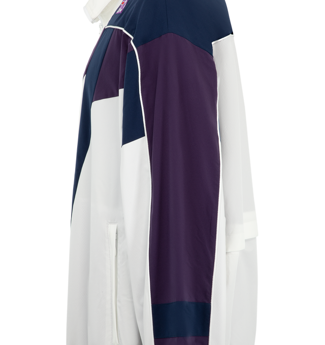 Image 3 of 3 - WHITE - Needles x Fila Men's Star Cut Oversized Windbreaker is crafted from polyester and features an oversized silhouette inspired by FILA's 1993 ski jacket, with bold color-blocked panels and sharp cut-line detailing. Created as part of the first collaboration between Needles and FILA, this lightweight outerwear style combines vintage performance influences with a contemporary streetwear aesthetic. Main Material: 100% Polyester. 
