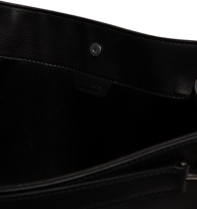 Image 3 of 3 - BLACK - The Row Alexia small tote bag in grained calfskin leather featuring leather shoulder straps with buckle accents and an open top with magnetic closure. Measures 11.6"H x 17.1"W x 6"D. Made in Italy. 