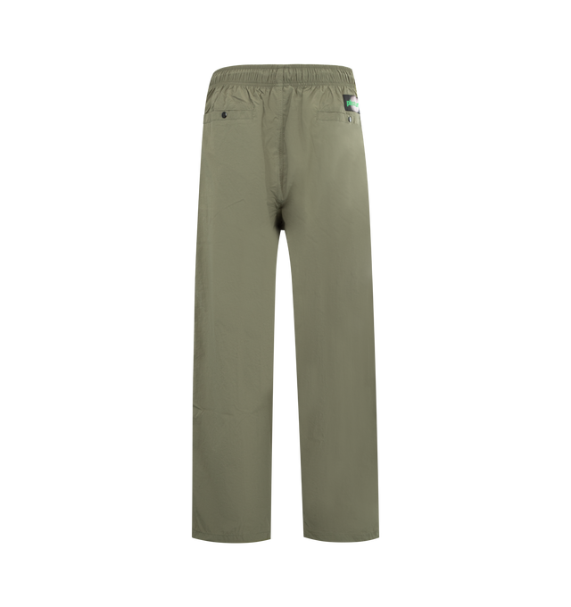 Image 2 of 3 - GREEN - PLEASURES Sound Track Pant featuring piping detail, elasticized waist, relaxed fit, snap button front and back pockets, logo patch and full length. 100% nylon taslan. 