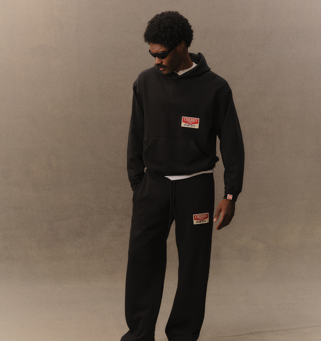 Image 4 of 6 - BLACK - Cherry LA Chevron Parachute Sweatpants are crafted from custom cotton fleece and feature a wide-leg silhouette with a relaxed, laid-back fit. Designed with a patch detail at the leg, an adjustable drawcord waistband, and a branded label at the back pocket, these everyday sweatpants blend comfort-focused construction with Cherry LA's signature contemporary aesthetic. Main Material: Custom Cotton Fleece. Made in Los Angeles, USA. 