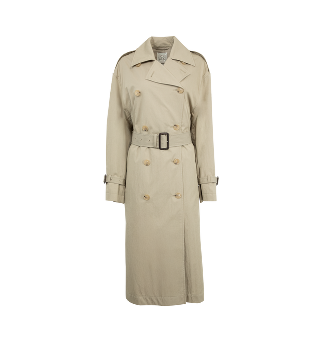 Image 1 of 3 - NEUTRAL - TOTEME Crisp Summer Trench featuring double-breasted button front, welt pockets, epaulettes, waist and cuff belts, inverted box pleat, t-stitch and light, water-resistant fabric. 65% cotton organic, 35% polyamide. Made in Portugal. 