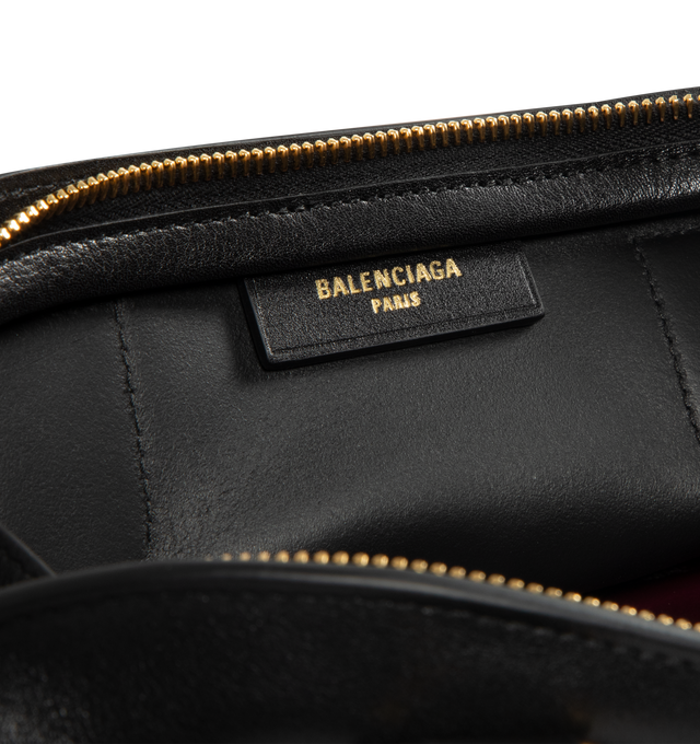 Image 4 of 4 - BLACK - BALENCIAGA Bolero Bowling Bag Mini featuring smooth calfskin, two handles with Bolero B logo, adjustable and removable strap, shoulder, crossbody and hand carry, aged-gold hardware, zipped closure with leather pull tab and ring, zipped pocket on the bottom with leather pull tab and ring, 1 main compartment and contrasting nappa lambskin lining. 11.8" x 5.1" x 6.3". Calfskin. Made in Italy. 
