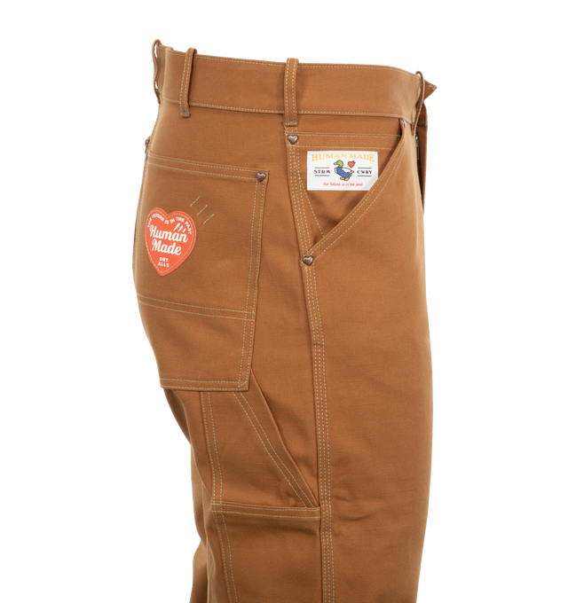 Image 4 of 4 - BROWN - Human Made Men's Straight silhouette work pants made of duck fabric. The paper label on the back pocket changes with each wash, and when all the labels are removed, the heart-shaped stitching reveals the outline. 100% COTTON. 