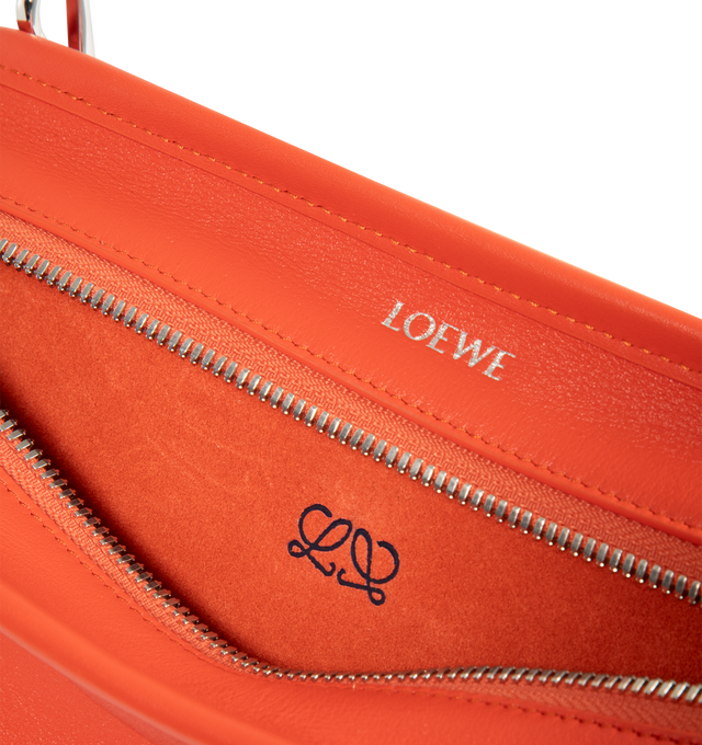 Image 4 of 4 - ORANGE - Loewe Small Amazona 180 Bag in leather features a relaxed silhouette anchored by a single toron top handle, designed to be carried open, while a concealed closure secures the main compartment, three carry options: short handle, removable shoulder strap and crossbody, zip closure with two leather zip pullers, two compartments, main compartment closed with magnetic closure, internal flat pocket, left side d-ring for customization, nappa lambskin lining, and embossed double L branding.  