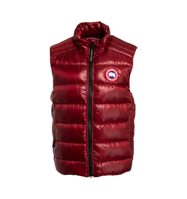 Image 1 of 2 - RED - CANADA GOOSE Crofton Down Vest featuring stand collar, two-way zip closure, embroidered logo patch at chest, zip pockets, patch pocket at interior, packable down-filled, lightweight, water-repellent, wind-resistant, and fully lined. 100% polyamide. Lining: 100% polyamide. Fill: 90% duck down, 10% duck feather. Made in Canada. 