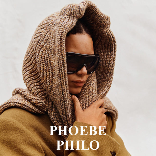 Person wearing a brown knitted hood and sunglasses with 'Phoebe Philo' branding. 